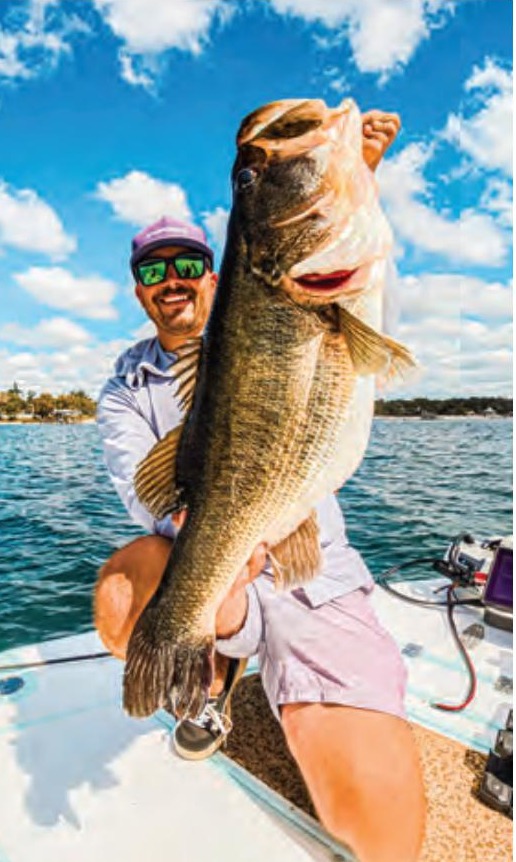 Capt. Tyler Woolcott holding a big largemouth bass