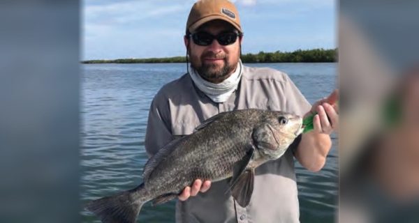 Angler holding a black drum