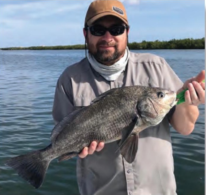 Angler holding a black drum