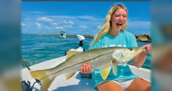Young angler holding a big snook