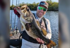 Kayak angler holding a big largemouth bass
