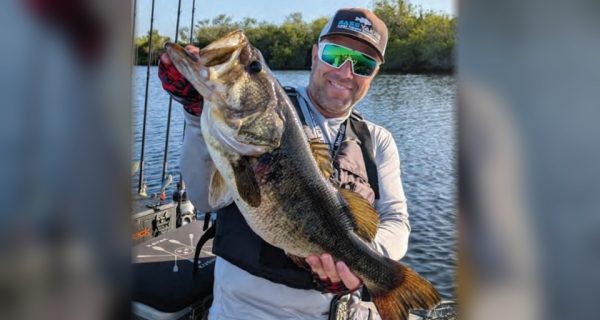 Kayak angler holding a big largemouth bass
