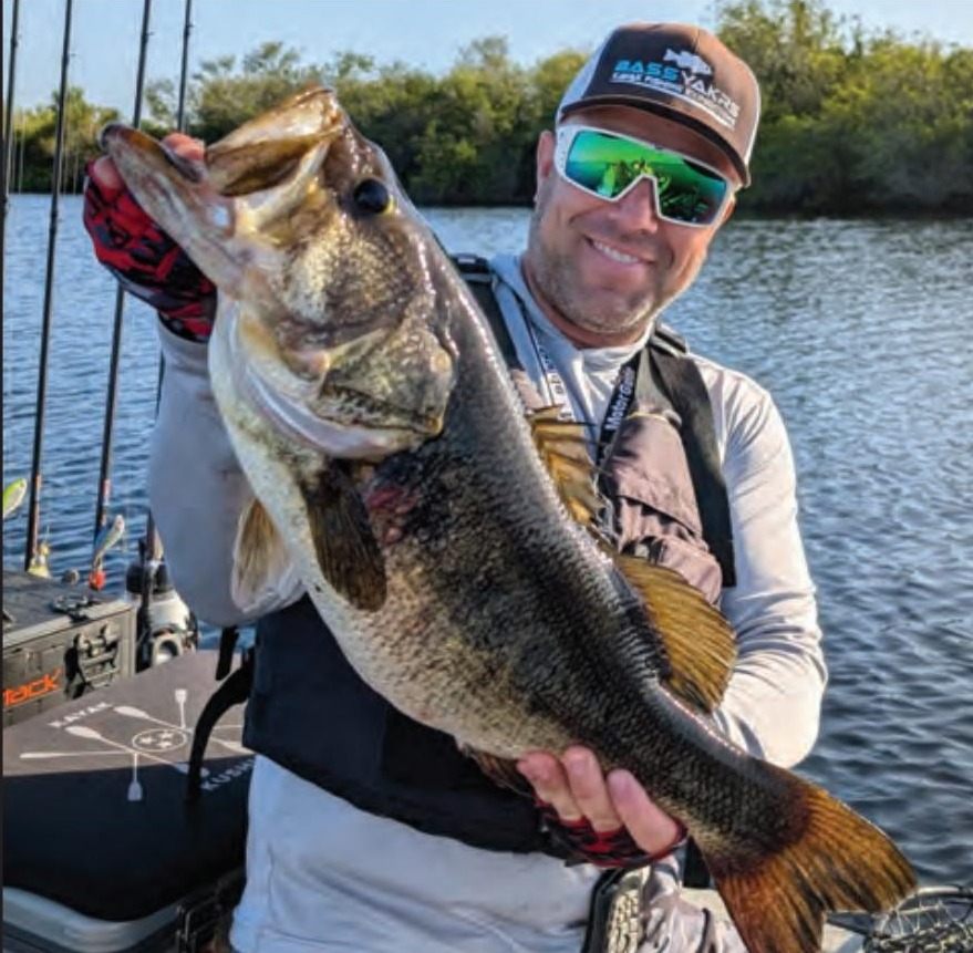Kayak angler holding a big largemouth bass