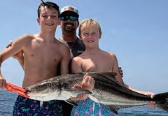 Youth anglers Mikey Stamps and Quintin Ray with Capt. Evan Sanders and their cobia