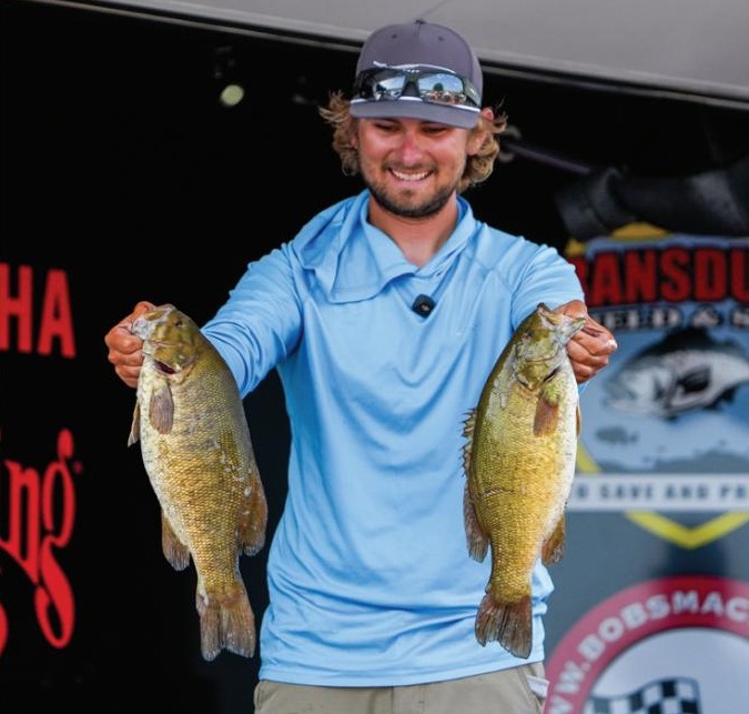Pro bass angler Joey Bloom holding two smallmouth bass