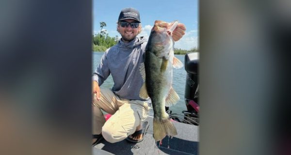 Pro bass angler Joey Bloom holding a largemouth bass