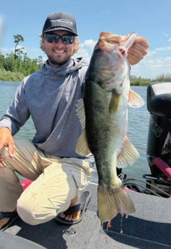 Pro bass angler Joey Bloom holding a largemouth bass
