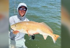 Capt. Austin Ferguson of Ferg's Guide Service holding a redfish on his boat