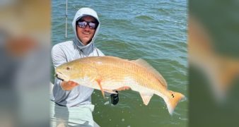 Capt. Austin Ferguson of Ferg's Guide Service holding a redfish on his boat