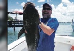 Angler holding a large fish on a boat