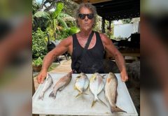 Angler with a cleaning table of pompano and other surf-caught fish