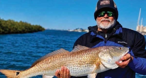 Captain Brian Gober of Rare Breed Charters holding a redfish near Ponce Inlet