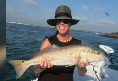 Angler holding a redfish on a Yellow Dawg Fishing charter near Ponce Inlet