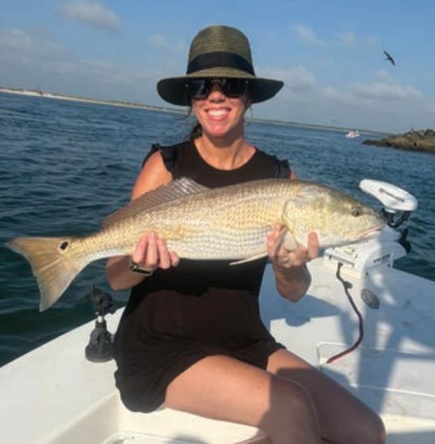 Angler holding a redfish on a Yellow Dawg Fishing charter near Ponce Inlet